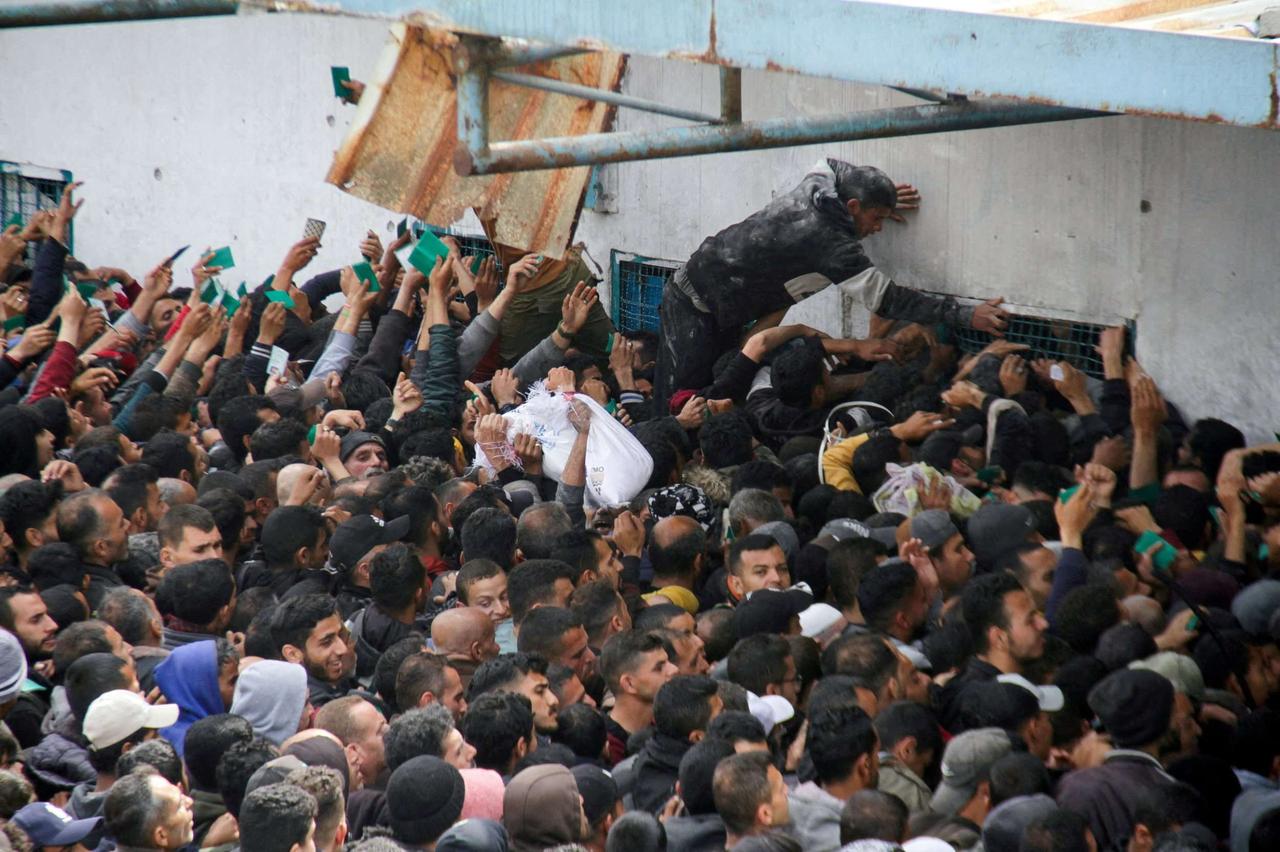 Des Palestiniens se massent à l’extérieur d’un établissement de l’UNRWA pour recevoir de l’aide alimentaire. Gaza Ville, 18 mars 2024. © Mahmoud Issa / REUTERS